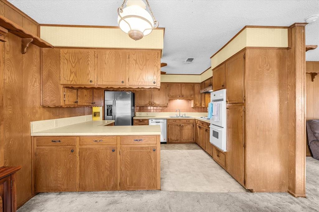 601 State Street Weatherford, TX 76086 - Photo 10 of 38 a kitchen with a sink refrigerator and cabinets