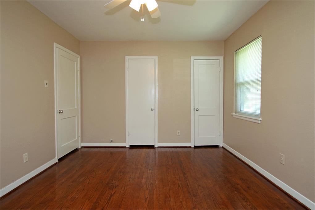 2332 Suffolk Drive Houston, TX 77027 - Photo 17 of 20 an empty room with wooden floor and windows