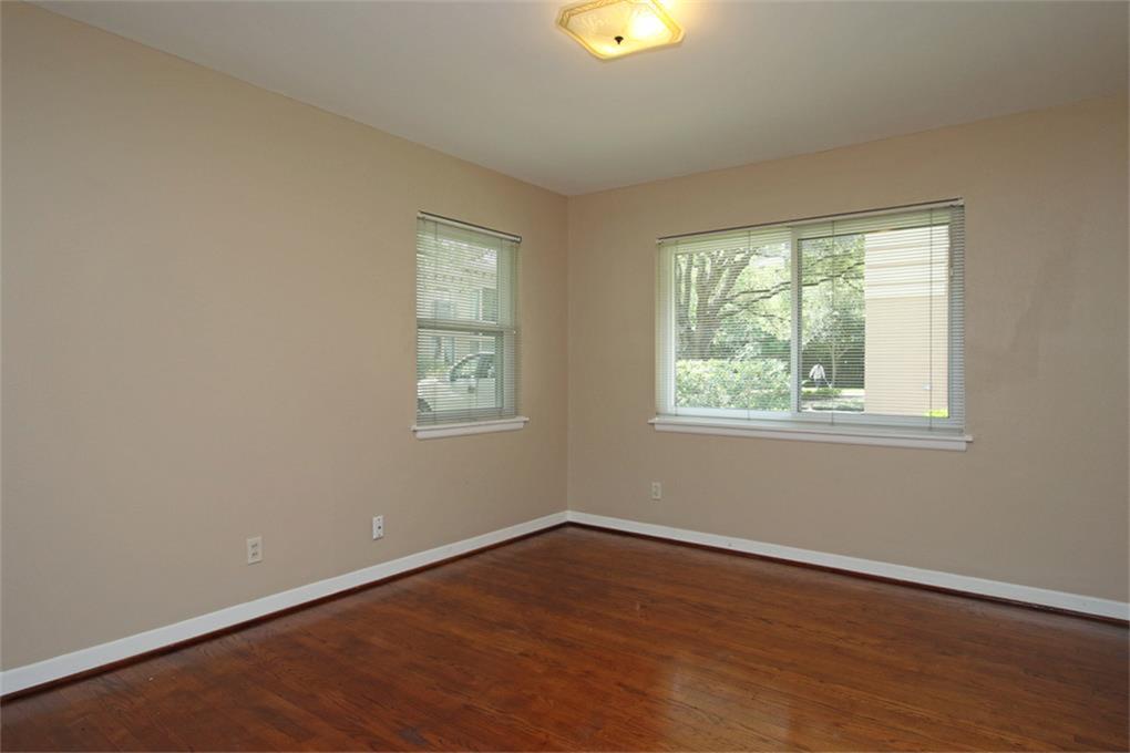 2332 Suffolk Drive Houston, TX 77027 - Photo 18 of 20 an empty room with wooden floor and windows