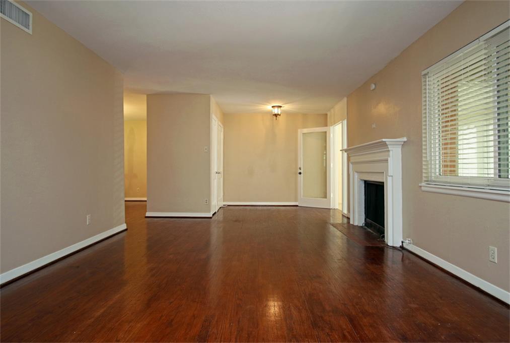 2332 Suffolk Drive Houston, TX 77027 - Photo 4 of 20 an empty room with wooden floor and fireplace