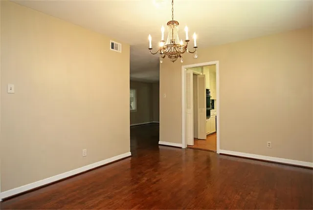 a view of a room with wooden floor and chandelier