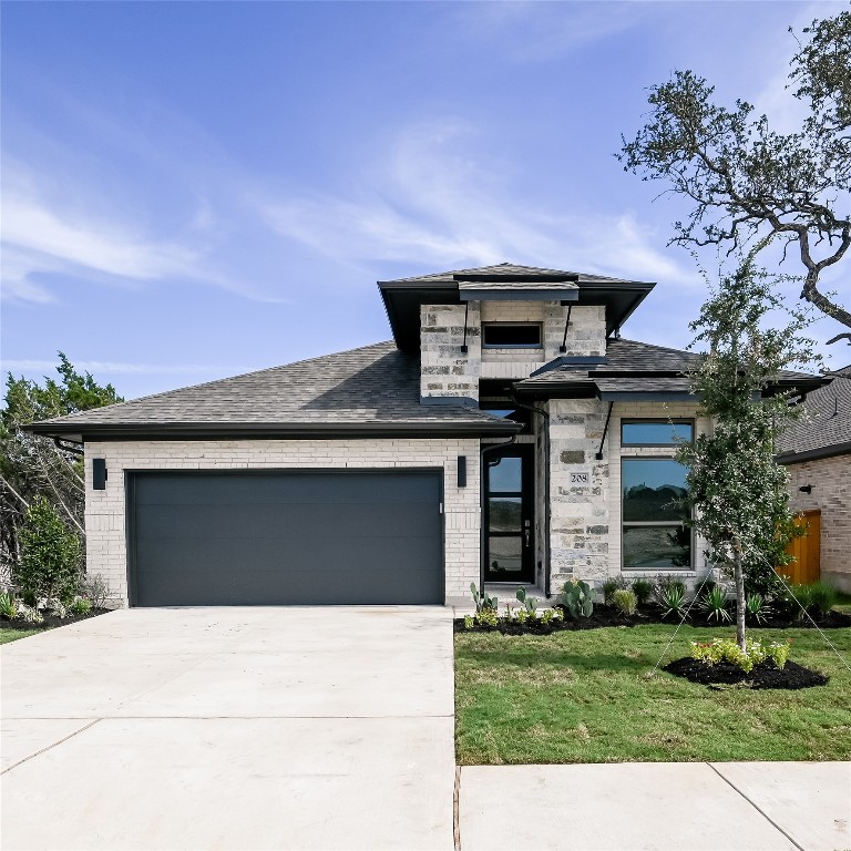 208 High Rock Pass Kyle, TX 78640 - Photo 2 of 40 Prairie-style house with brick siding, concrete driveway, an attached garage, and roof with shingles