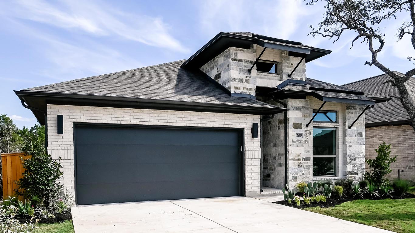 208 High Rock Pass Kyle, TX 78640 - Photo 3 of 40 View of front of home featuring stone siding, a garage, driveway, and roof with shingles