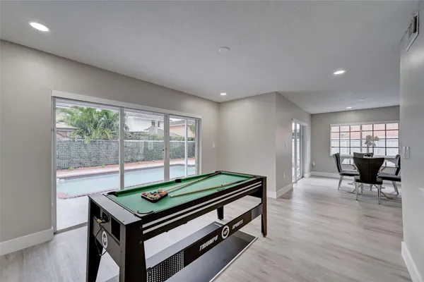 a room with pool table and two windows