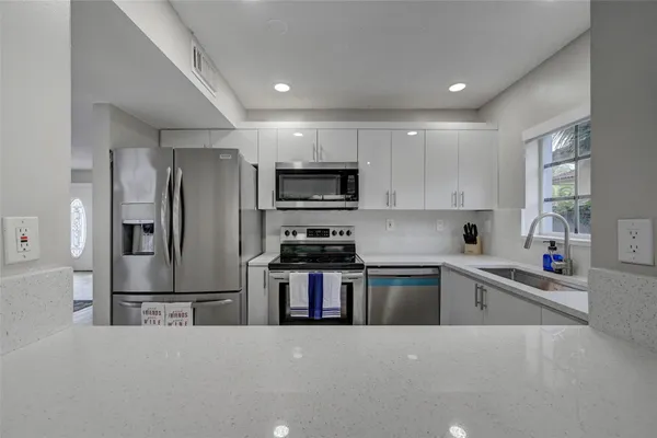 a kitchen with granite countertop a refrigerator and a sink
