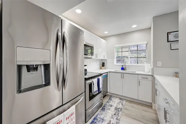 a kitchen with stainless steel appliances a refrigerator sink and cabinets