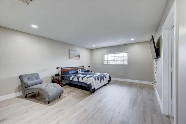 a bedroom with a bed and wooden floor