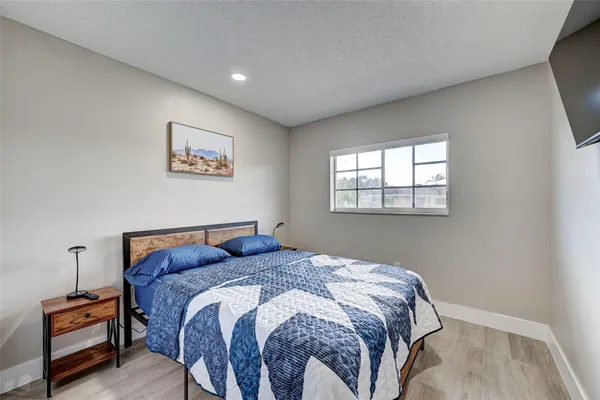 a bedroom with a bed and painting on the wall