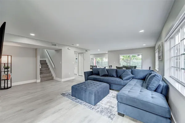 a living room with furniture and a wooden floor