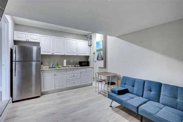 a kitchen with white cabinets and refrigerator