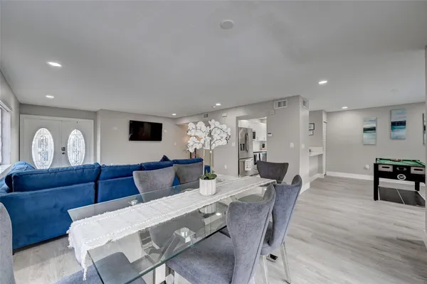 a living room with furniture a flat screen tv and kitchen view