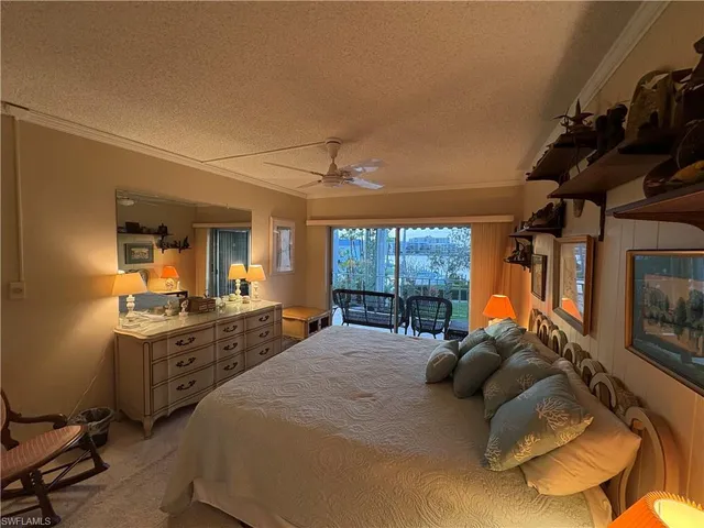 a bed room with a bed mirror and a chair