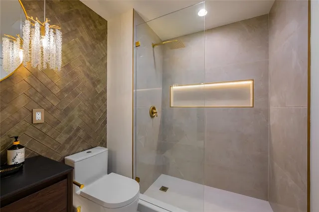 a white toilet sitting next to a bathroom sink and vanity