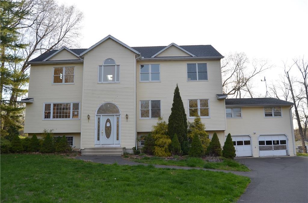 75 Woodside Road Guilford, CT 06437 - Photo 1 of 1 a front view of a house with a garden and plants