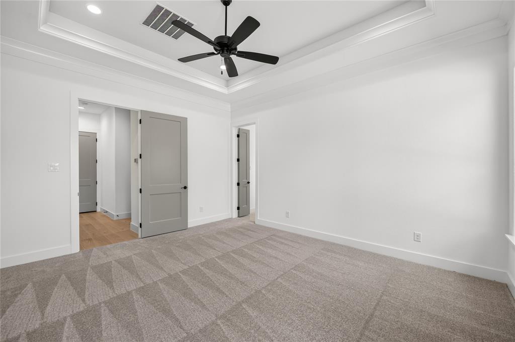 114 Red Bud Road Boyd, TX 76023 - Photo 16 of 32 Spacious room featuring a tray ceiling with a black ceiling fan, light gray patterned carpeting, and white walls