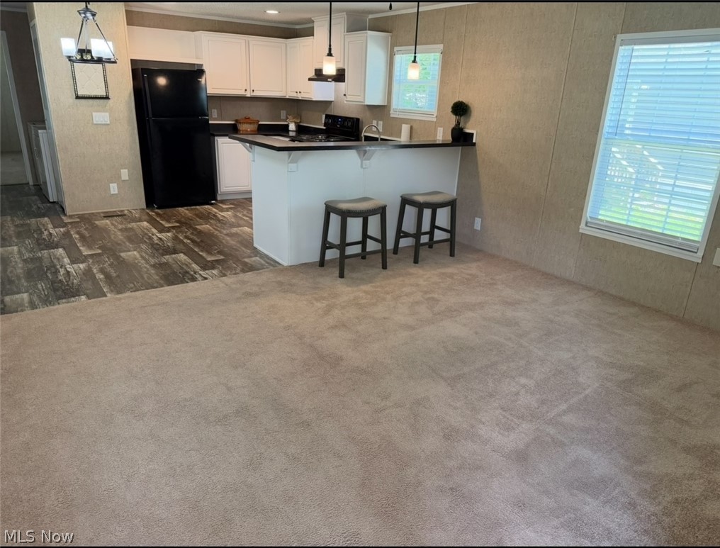 202 West Main Road, Unit 139 Conneaut, OH 44030 - Photo 44 of 45 Open-concept living space featuring a kitchen with white cabinetry, black countertops, and a full suite of black appliances