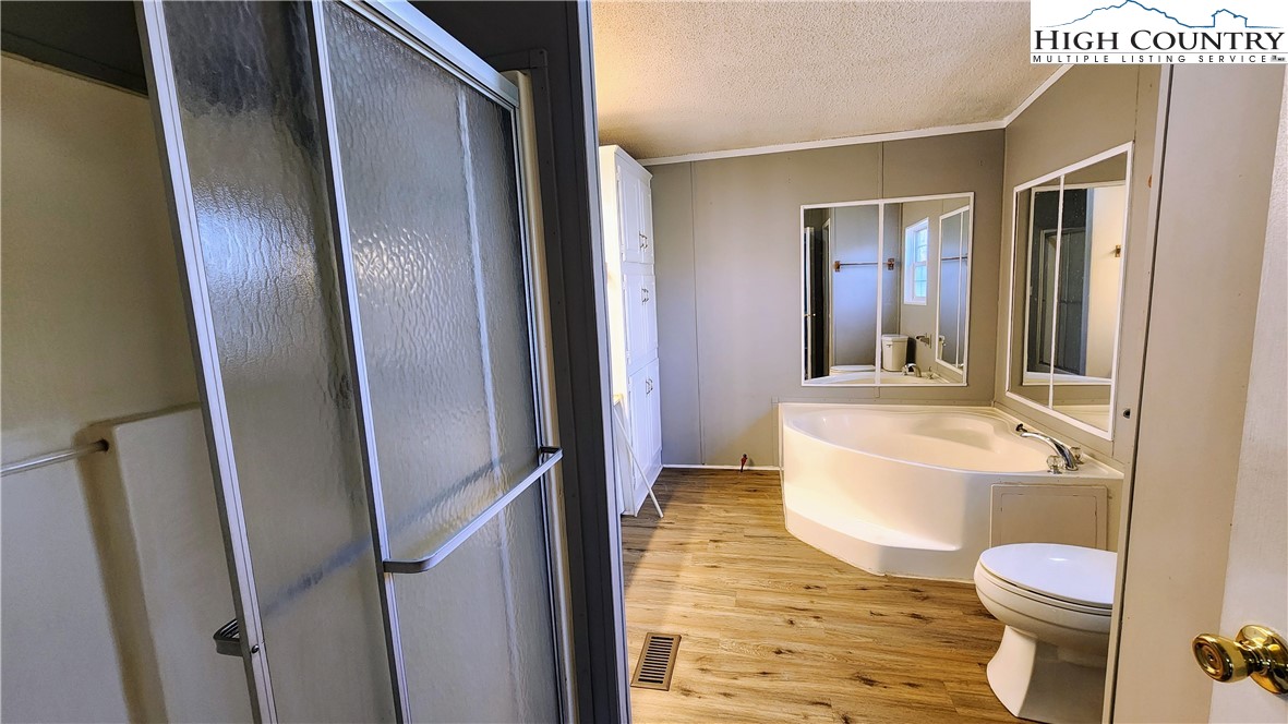 68 Rhoneys View Road Newland, NC 28657 - Photo 23 of 37 a bathroom with a sink a toilet a mirror and bathtub