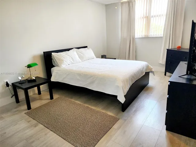 a bedroom with a bed and a large window