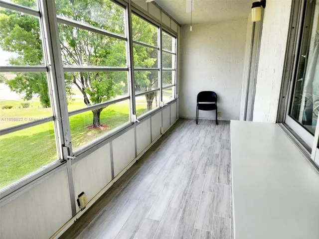 a living room with stainless steel appliances kitchen island granite countertop a dining table chairs and a large window