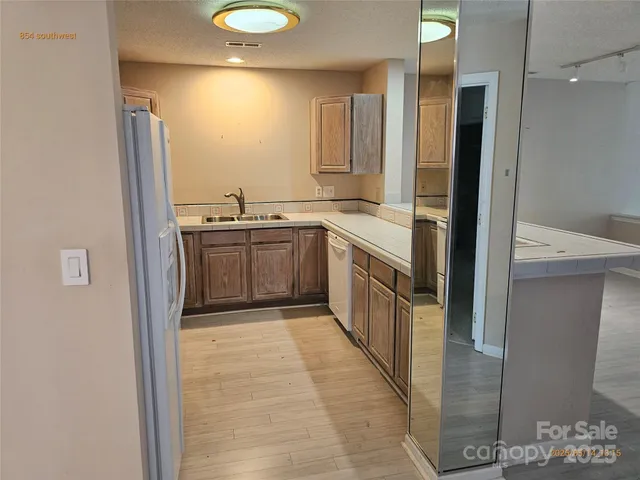 a large kitchen with stainless steel appliances granite countertop a sink and cabinets with wooden floor