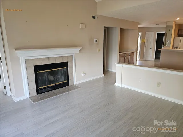 an empty room with wooden floor and fireplace