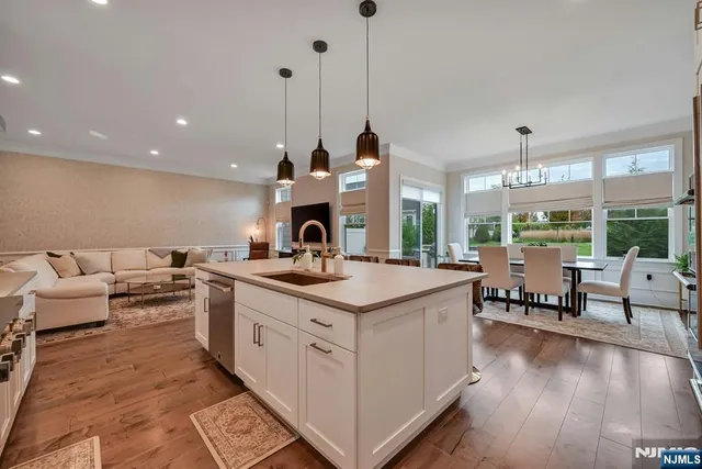 a kitchen with stainless steel appliances granite countertop a stove and a view of living room