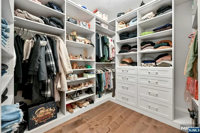 a view of walk in closet with clothes and shoes