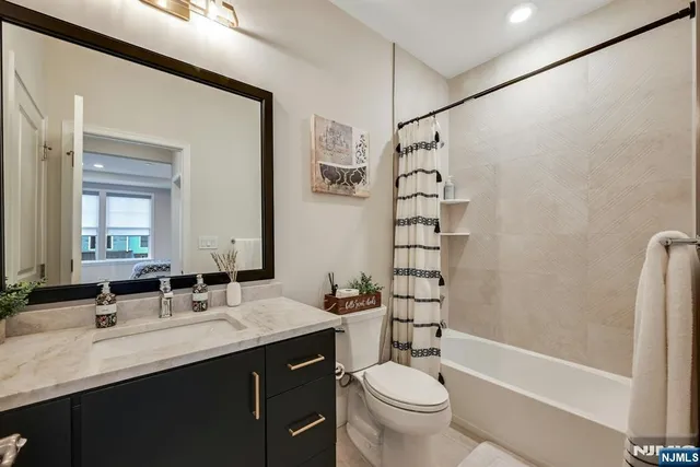 a bathroom with a double vanity sink toilet mirror and shower