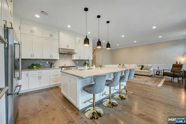 a kitchen with a table chairs stove and white cabinets