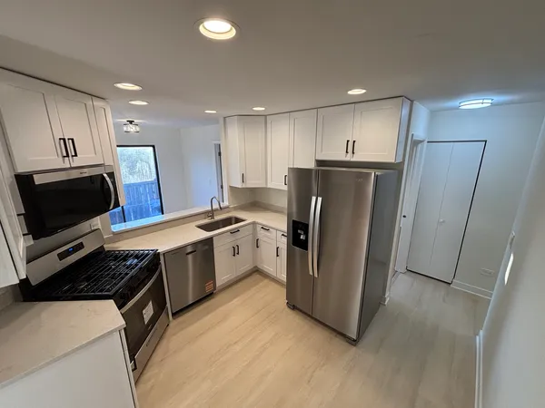 a kitchen with a refrigerator a sink and a microwave