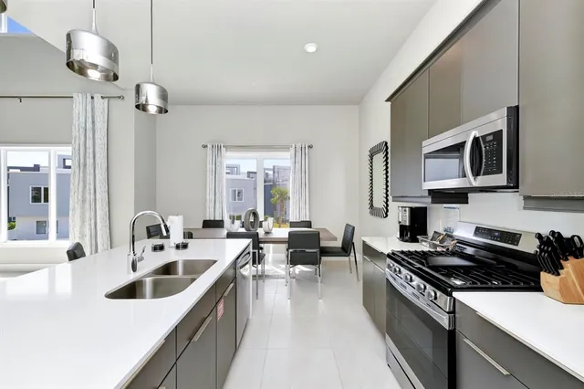 a kitchen that has a sink and a stove top oven