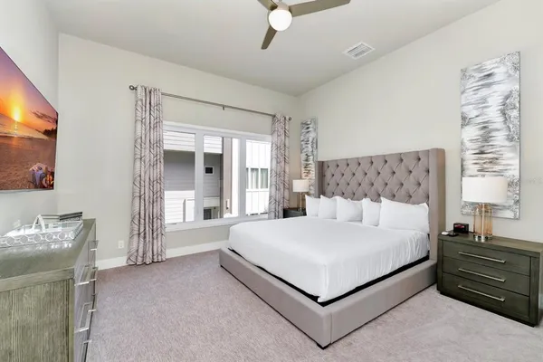 a large bedroom with a bed and large windows