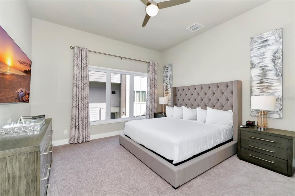 7740 Sandy Ridge Drive, Unit 220 Reunion, FL 34747 - Photo 18 of 55 a large bedroom with a bed and large windows