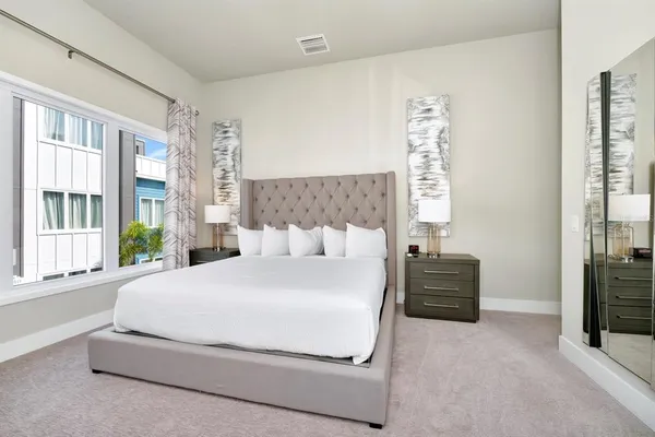 a large bed sitting in a bedroom next to a window