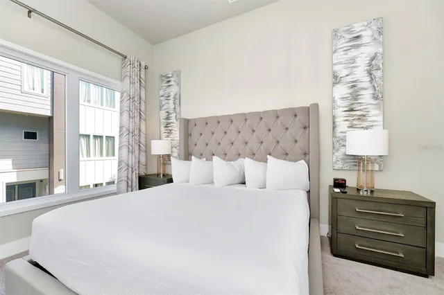 a spacious bedroom with a bed and a flat screen tv