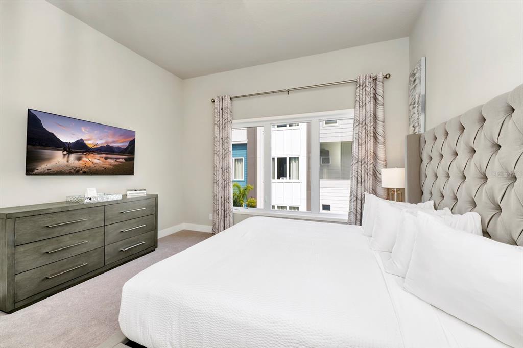 7740 Sandy Ridge Drive, Unit 220 Reunion, FL 34747 - Photo 21 of 55 a spacious bedroom with a bed and a flat screen tv