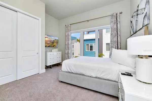 a bedroom with a bed and a flat tv screen on dresser