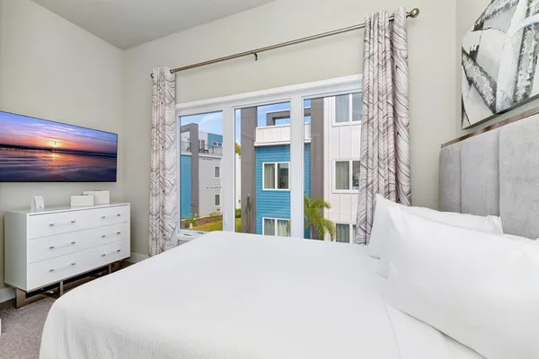 a bedroom with a bed and a large window