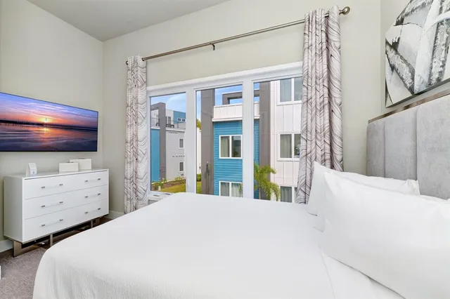 a bedroom with a bed and a large window