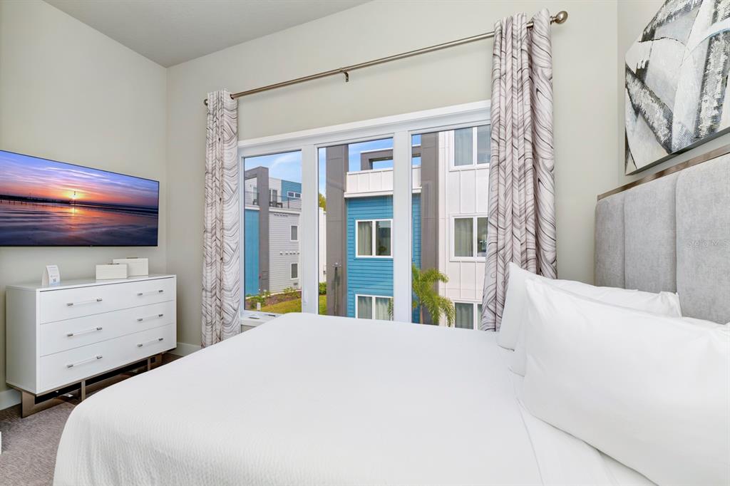 7740 Sandy Ridge Drive, Unit 220 Reunion, FL 34747 - Photo 25 of 55 a bedroom with a bed and a flat tv screen on dresser