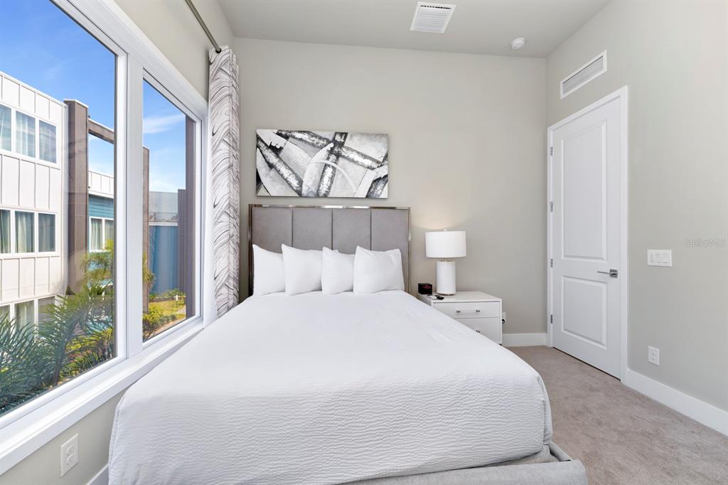 7740 Sandy Ridge Drive, Unit 220 Reunion, FL 34747 - Photo 26 of 55 a bedroom with a bed and a large window