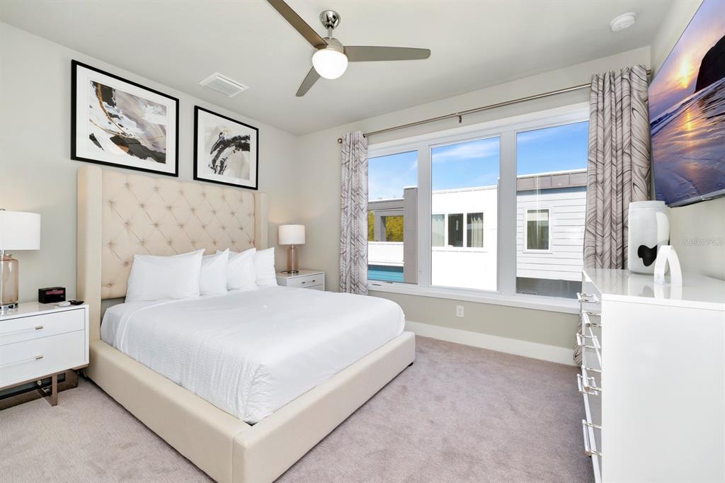 7740 Sandy Ridge Drive, Unit 220 Reunion, FL 34747 - Photo 38 of 55 a bedroom with a large bed and a chandelier