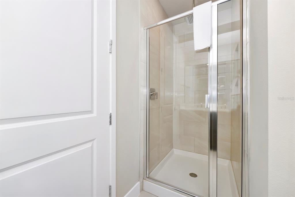 7740 Sandy Ridge Drive, Unit 220 Reunion, FL 34747 - Photo 41 of 55 a bathroom with a glass shower door