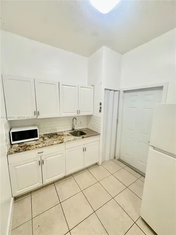 a kitchen with white cabinets and white appliances