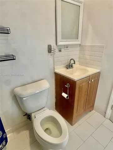 a bathroom with a granite countertop toilet sink and mirror