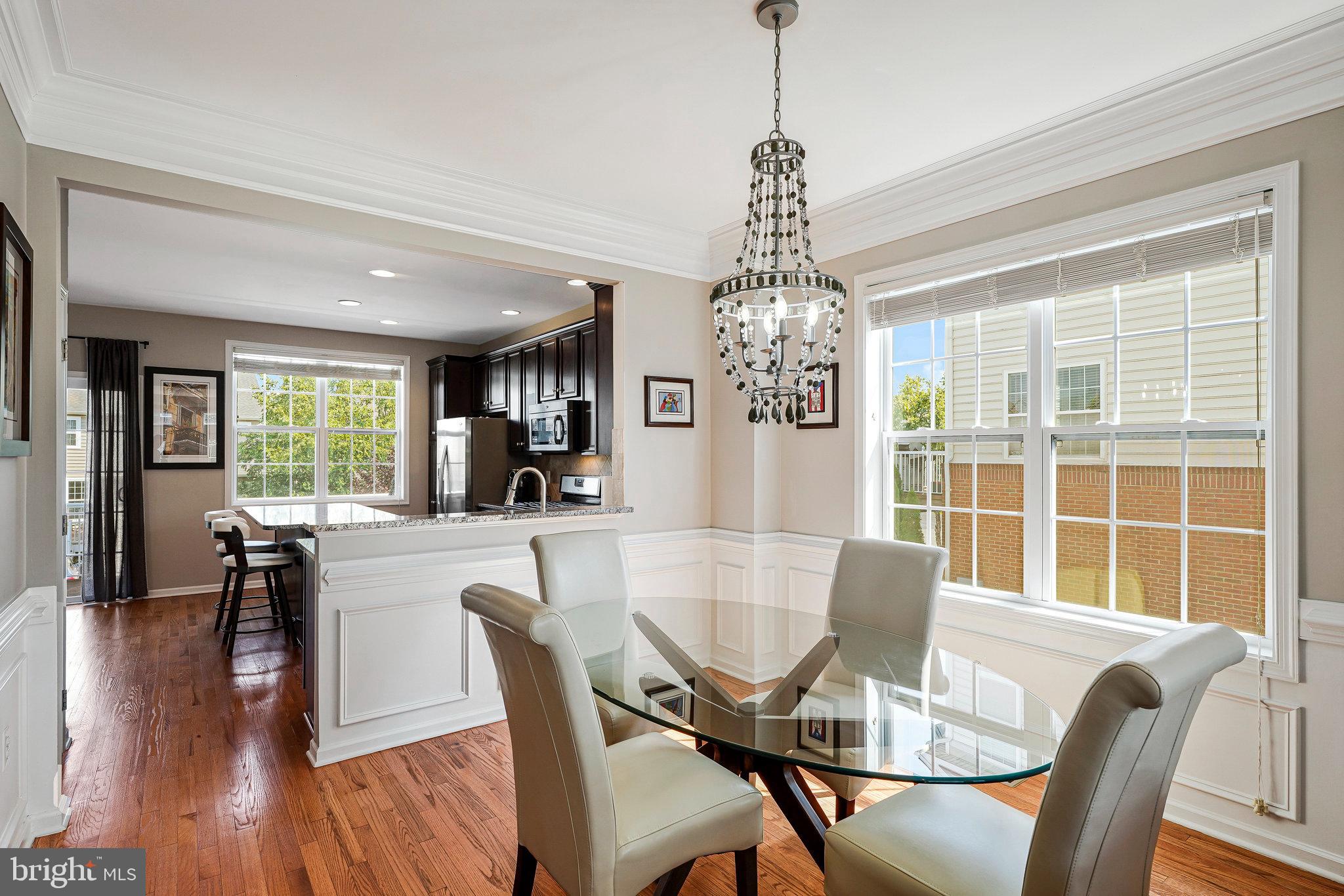 23073 Weybridge Square Broadlands, VA 20148 - Photo 5 of 24 a view of a dining room with furniture wooden floor and chandelier
