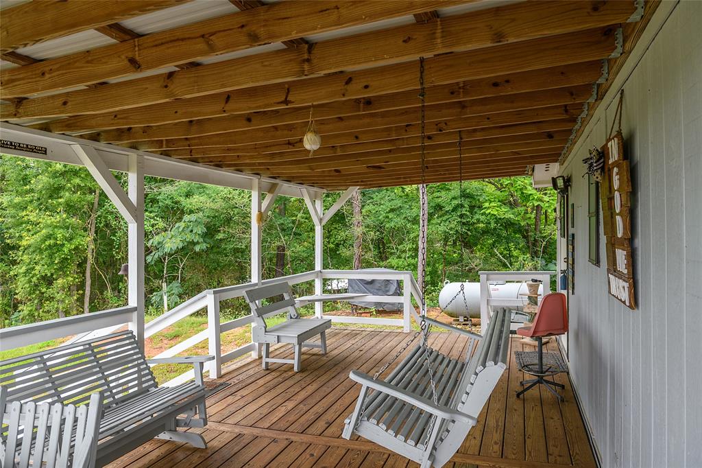 122 Grice Road Ringgold, LA 71068 - Photo 25 of 26 Expansive covered porch featuring wood-finish flooring, white railing, exposed wood ceiling beams, and a corrugated metal roof