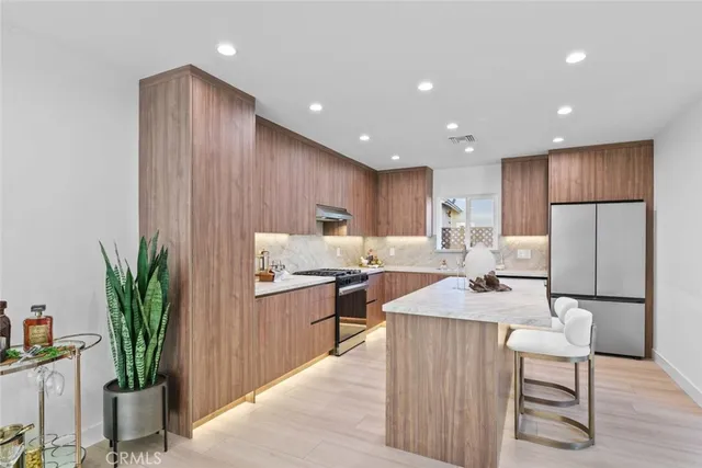 a kitchen with stainless steel appliances granite countertop a sink stove and a refrigerator