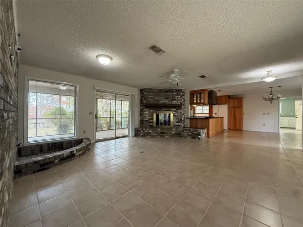a view of an empty room with a fireplace and a large window