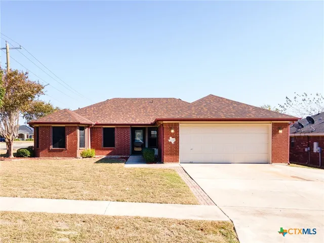 a front view of a house with a yard and a garage